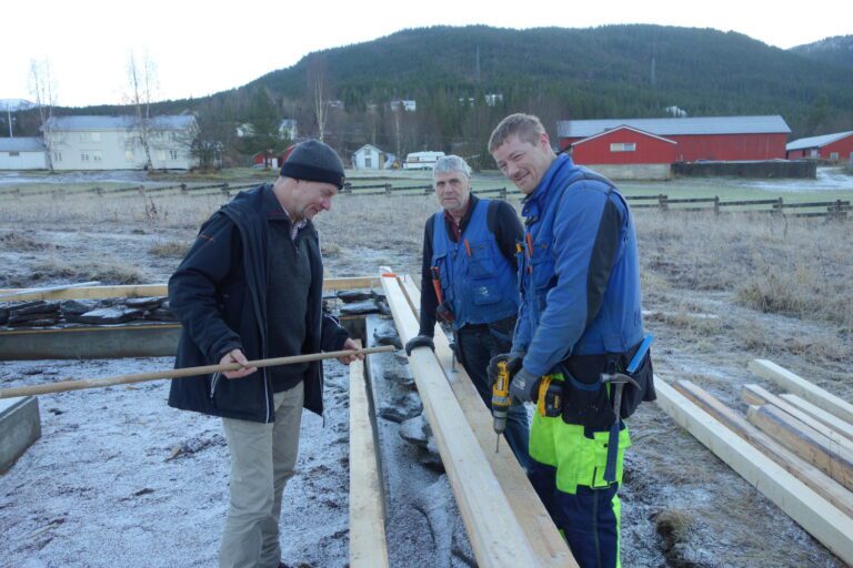 Prøttstaven klar. Geir Valla viser dimensjonen for de treproppene som skal binde sammen syllstokker og annen trekonstruksjon i den renoverte Korgen Bygdemølle. Mykensnekkerne Gudbjørn Gudbjørnsson og sønnen Arni Thor er eksperter på slikt arbeid, og det går både fort og effektivt framover.