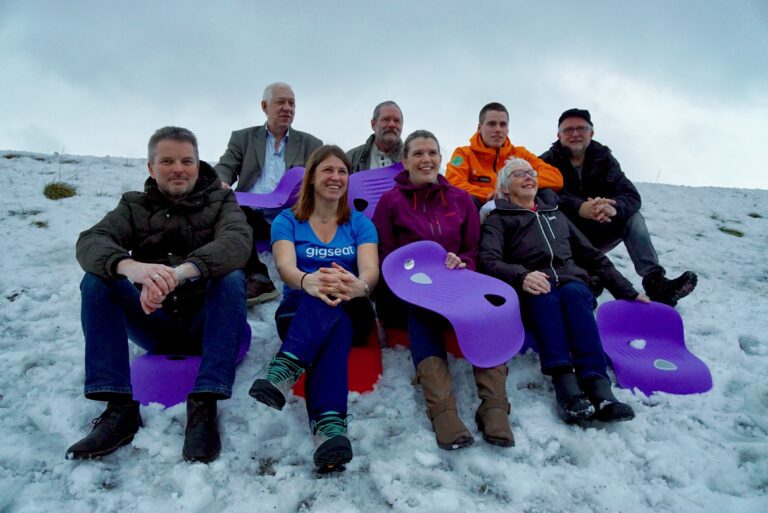 Hele gjengen samlet i en veiskråningen for å teste ut gaven de hadde fått. Fremst fra høyre Svein Erik Hjerpbakk (NCP), Marianne Texmo (Gigseat/Gigtrigger), Anne Karen Vasdal (Hemnes Turistforening), Eli Solhaug (Hemnesberget Vel). Bakerste rekke fra høyre. Magnar Skreslett (Hemnesjazz), Arnleif Finnes (Bleikvassli Idrettslag), Vegard Varem Vang (Norsk Folkehjelp) og Jon Arne Jacobsen (Klemetspelet)