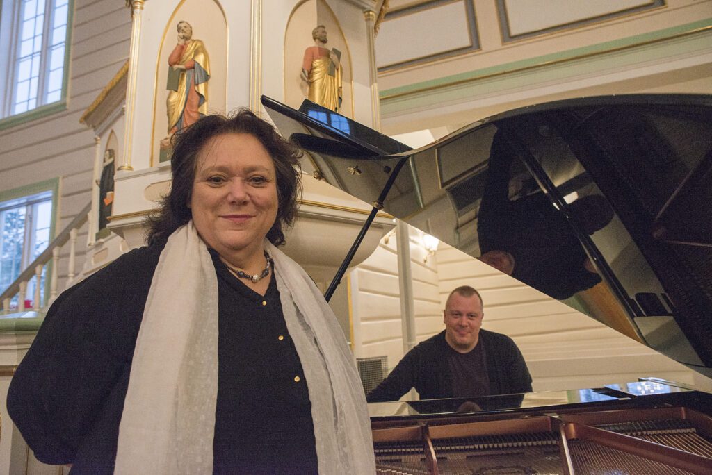 En fornøyd ordfører, Christine Trones, og organist Tor-Petter Aanes konstaterer at et nytt flygel er på plass i Korgen kirke.