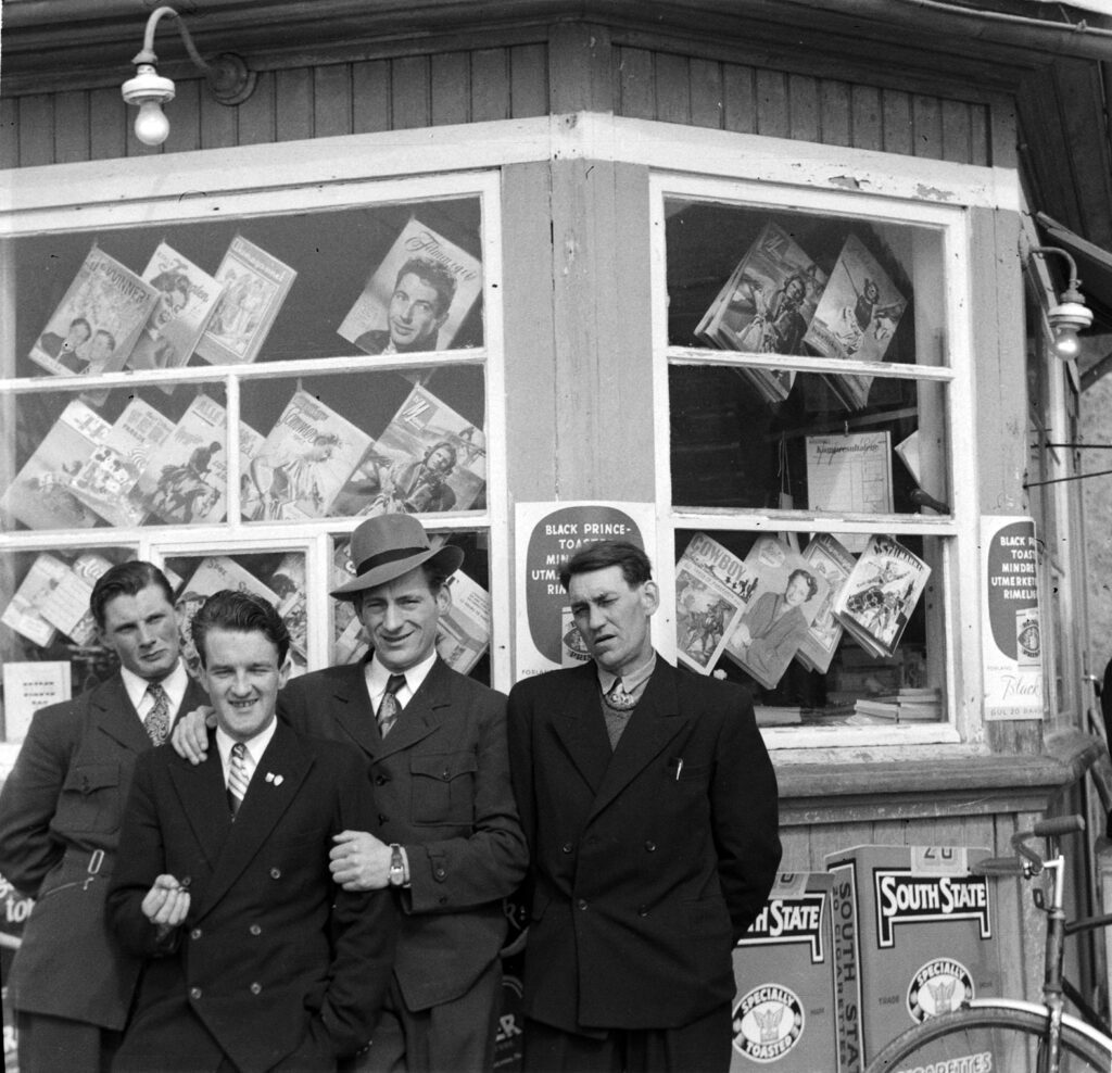 Helgesammenkomst ved Krestian-kiosken 1953. Sykkel er framkostmiddel og ukeblad er populær handelsvare.  Fra v.: Eilif Henriksen, Arvid Fjerldavli, Edgar Mathisen og Leif Karlsen