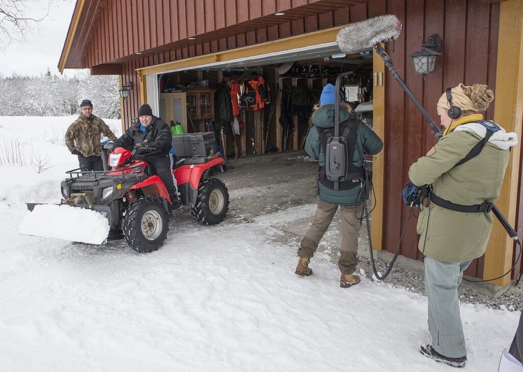 Bjørn-Terje viser sine vaktmesterkunster og rydder snø med firehjulingen, mens Morgen passer på, Kristine filmer og Tale tilpasser lyden.