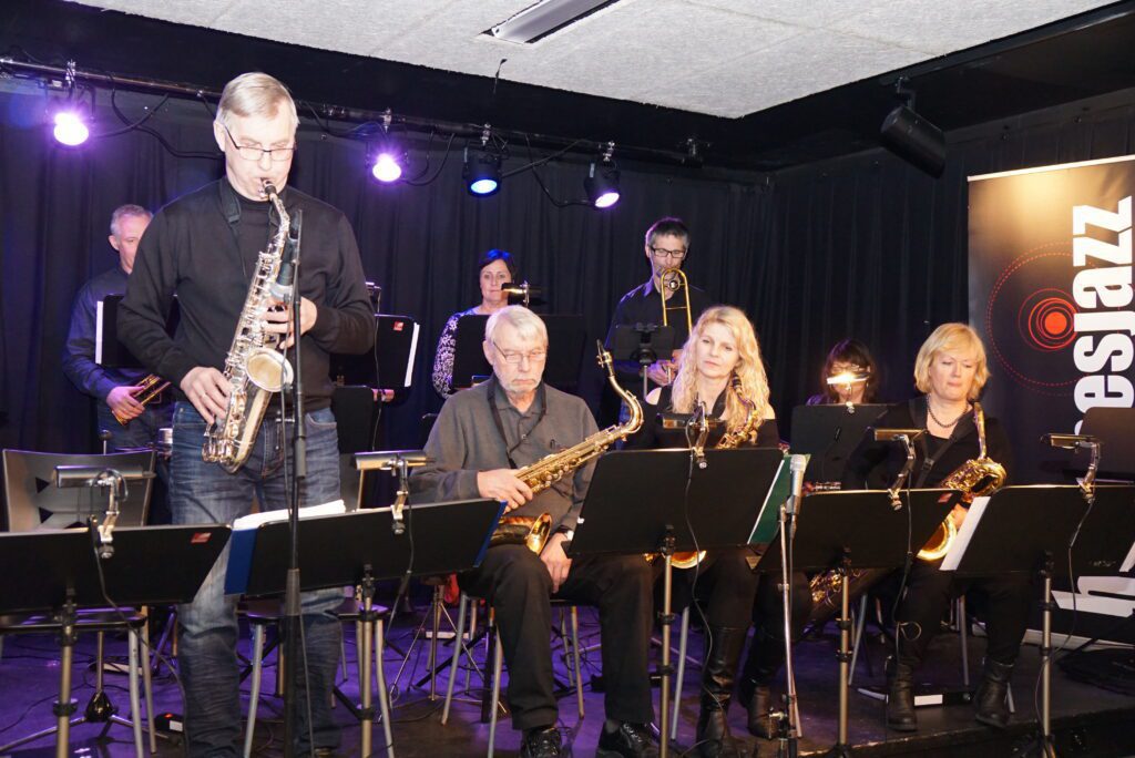 Stein Ivar Skjæran på altsax hadde flere fine solopartier under konserten på lørdag. Blåserekka besto av: Robert Finbak på trompet og flygelhorn, Trine Leirvik på trompet (delvis skjult), Tone Bente Båtstrand Husnes på trompet, Bjørn Fjeldavli på trombone, Sissel Marie Grøttebø på tenorhorn (sittende), Stein Ivar Skjæran på tenorsax, Ørnulf Skjæran på tenorsax og vokal,Gerd Sørmo på tenorsax og Grethe Johansen på barytonsax