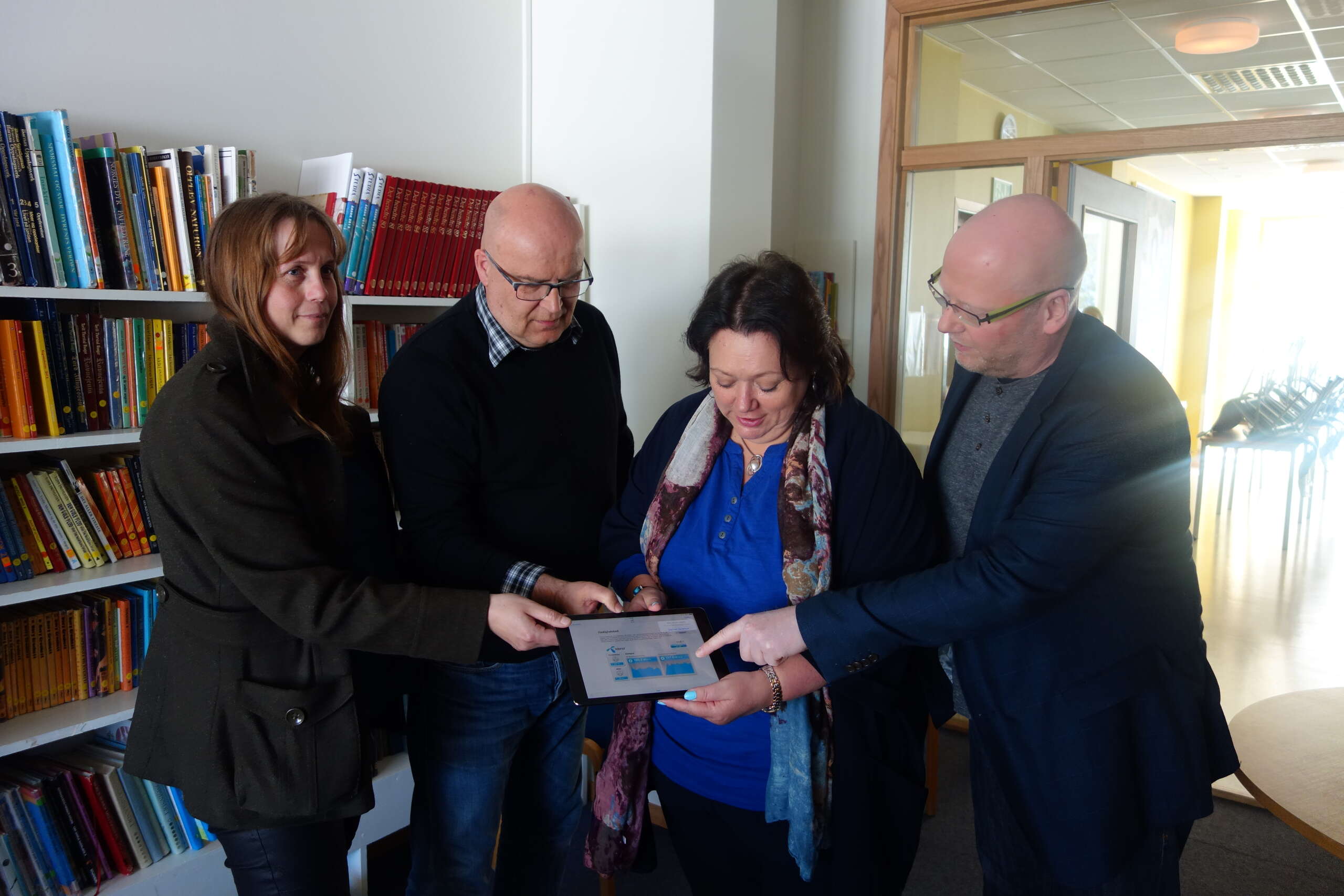 Barnehagestyrer Susanne Holmen og rektor Jon Ervik ser "fiberfarta" på nettbrettet sammen med ordfører Kristine Trones og enhetsleder Rollf Arne Westgaard.