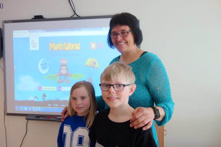 Lærer Hanne foran smartboardet sammen med Ayla og Aksel.