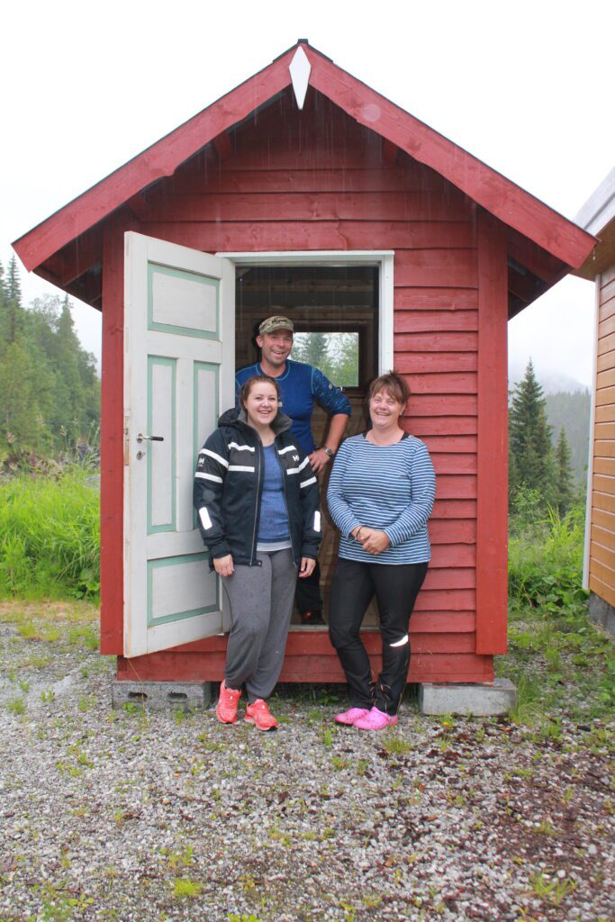 Thore Rønning (bak), Camilla Martinsen (venstre og Monica Aasen foran bua som loddes ut under UL Breidablikks 100-årsjubileum.