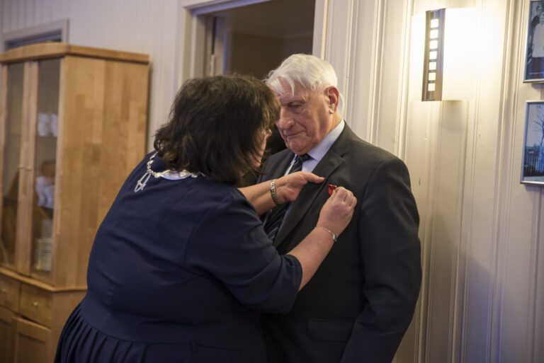 Ordfører Christine Trones plasserer medaljen på Brygfjells dress