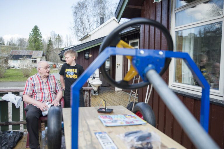 Jostein forteller at det viktigste med olabilbyggingen er at de har et prosjekt sammen.|Et personlig skilt skal monteres på olabilen. Dette hang en gang på vogna til Samuel da han var baby.|Jostein og Samuel har tatt olabilbygging til nye høyder