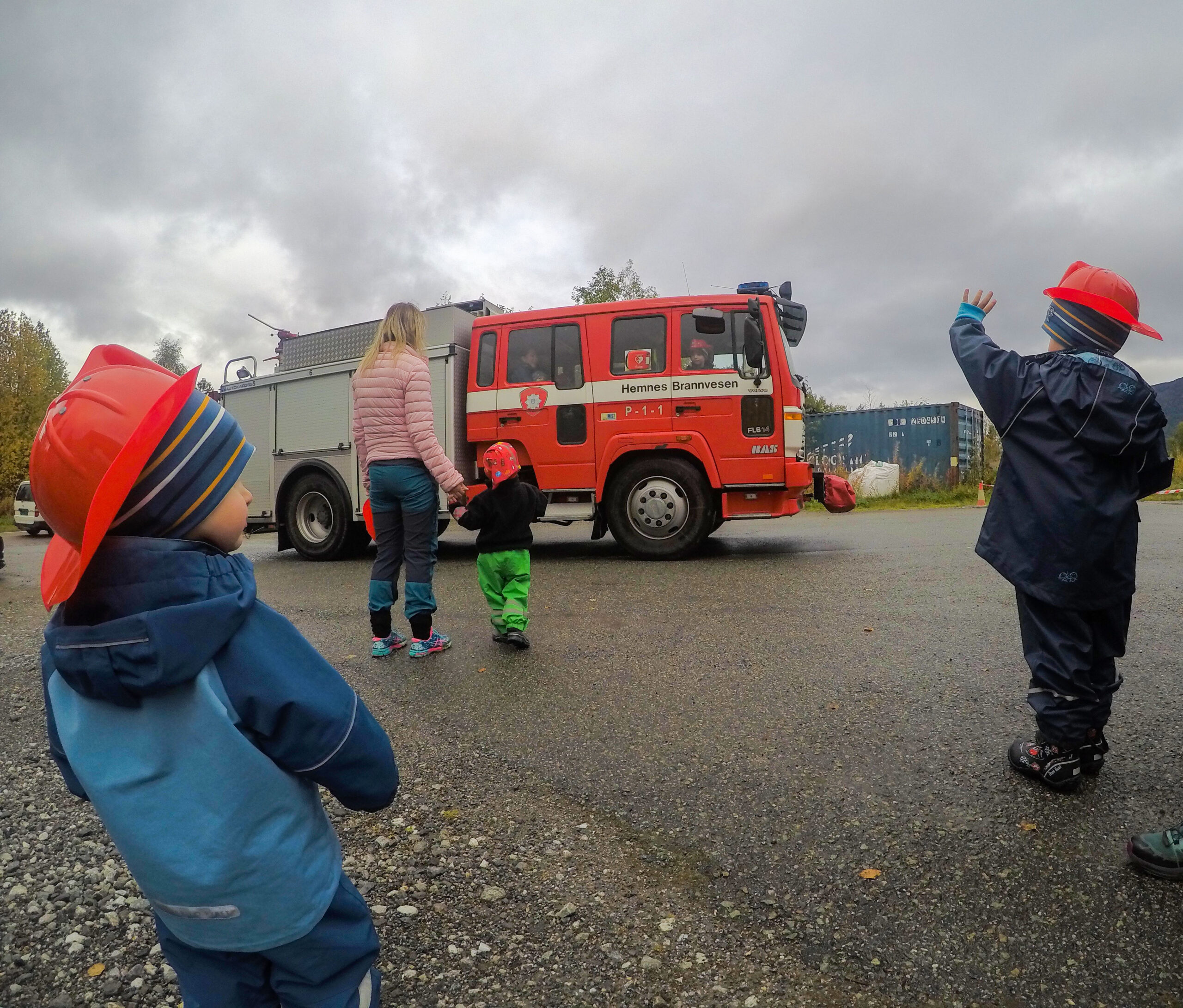 All oppmerksomheten går til brannbilen når den kommer kjørende inn på plassen.|Niclas har fått sitte på i brannbil