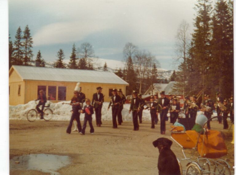 Korgen Skolemusikkorps spilte på tørr asfalt 17.mai-76. Snøskavlene var fortsatt høye langt uti mai. Johan Jørgen og Karla Iversens nybygde hus sees i bakgrunn.