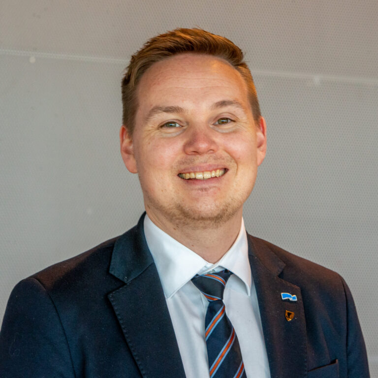 Portrett av person foran grå vegg.